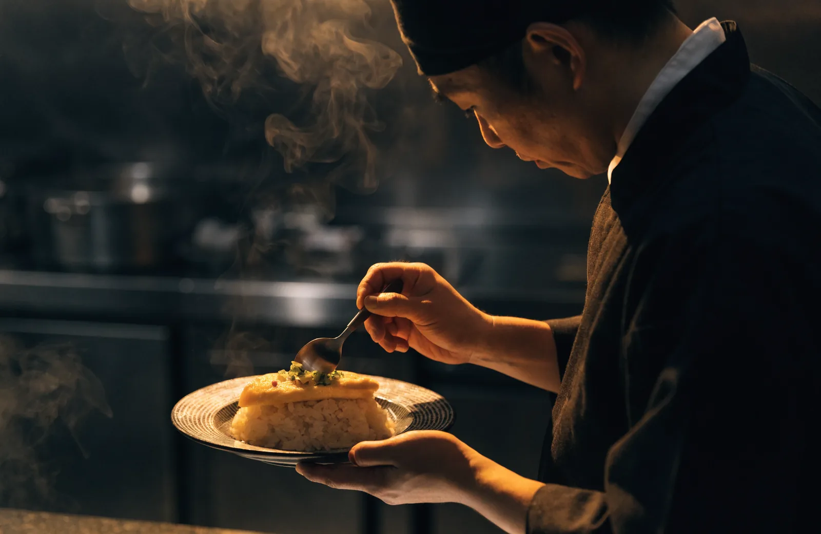 厨房で一皿を仕上げる料理長
